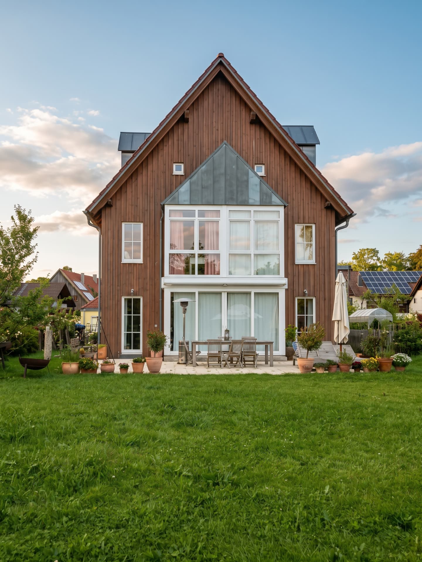 Haus am Moosbach von der Gartenseite mit Terrasse und Wiese